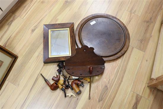 Two treen trays, a Victorian rosewood frame mirror and various smoking pipes and a rack, largest 47cm